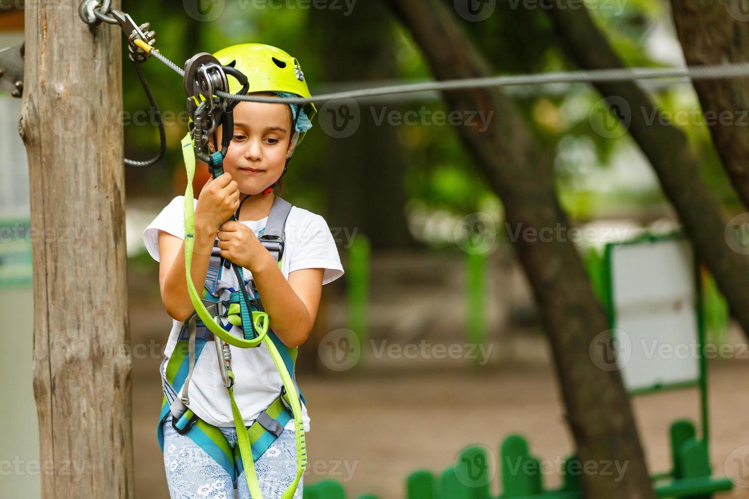 förtjusande liten flicka njuter henne tid i klättrande äventyr parkera på värma och solig sommar dag. sommar aktiviteter för ung ungar. barn har roligt på skola semestrar. foto