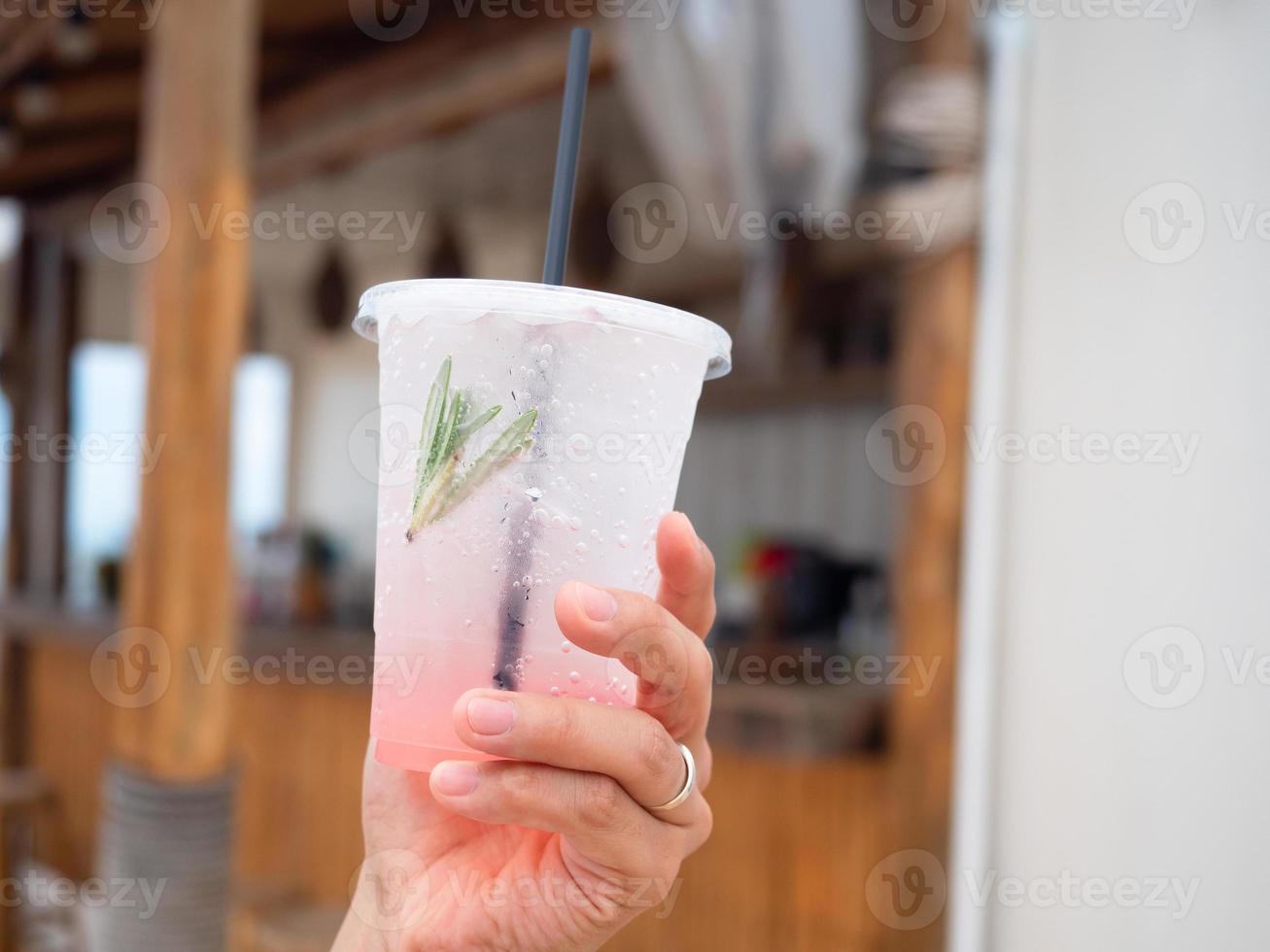 stänga upp hand innehav röd bär soda med Kafé se bakgrund foto