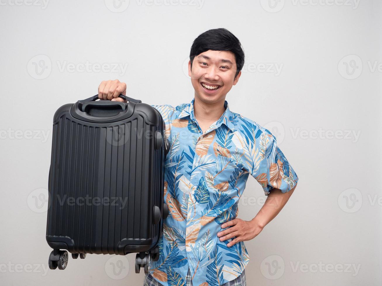 positiv ung man leende innehav bagage vit bakgrund foto