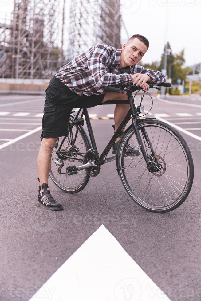 stilig manlig hipster på en cykel i de stad gata. foto