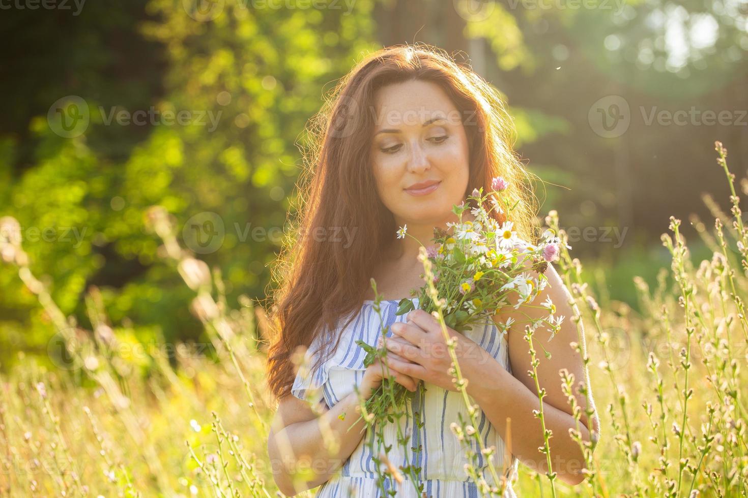 ung kvinna gående bland vild på solig sommar dag. begrepp av de glädje av kommunicerar med sommar natur foto