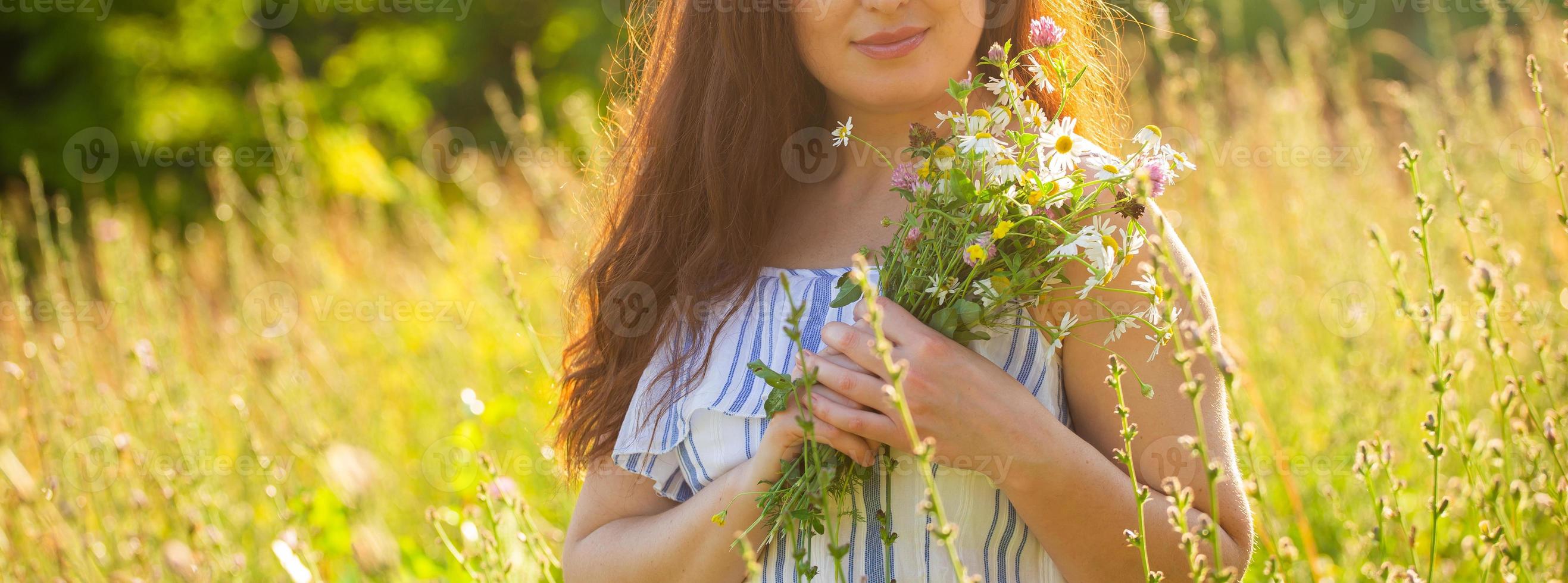 ung kvinna plockning blommor i de äng i sommar kväll foto