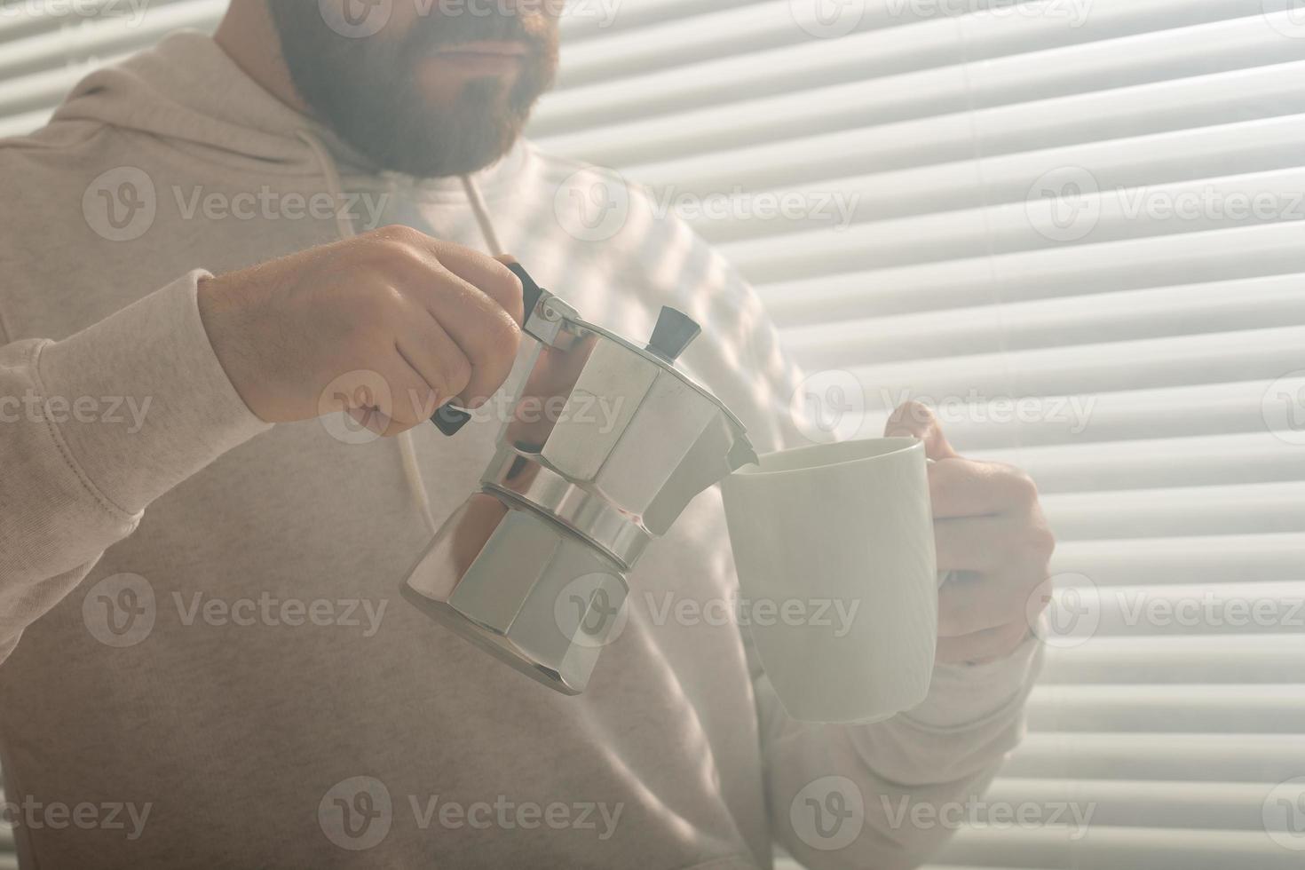 närbild porträtt av ung eleganta hipster manlig häller kaffe på kontor på sommar dag. begrepp av uppfriskande morgon- och positiv humör foto