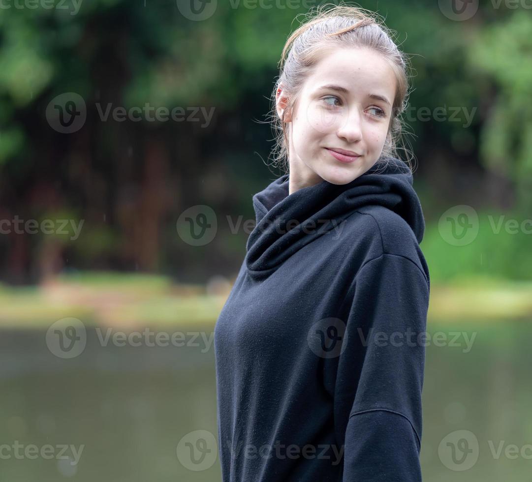 porträtt av ung flicka leende. skön kvinna stående ett person utomhus. en glad, lång brunetthårig, brun ögon kvinna har en positiv känsla frihet av fritid aktivitet i en naturlig parkera. foto