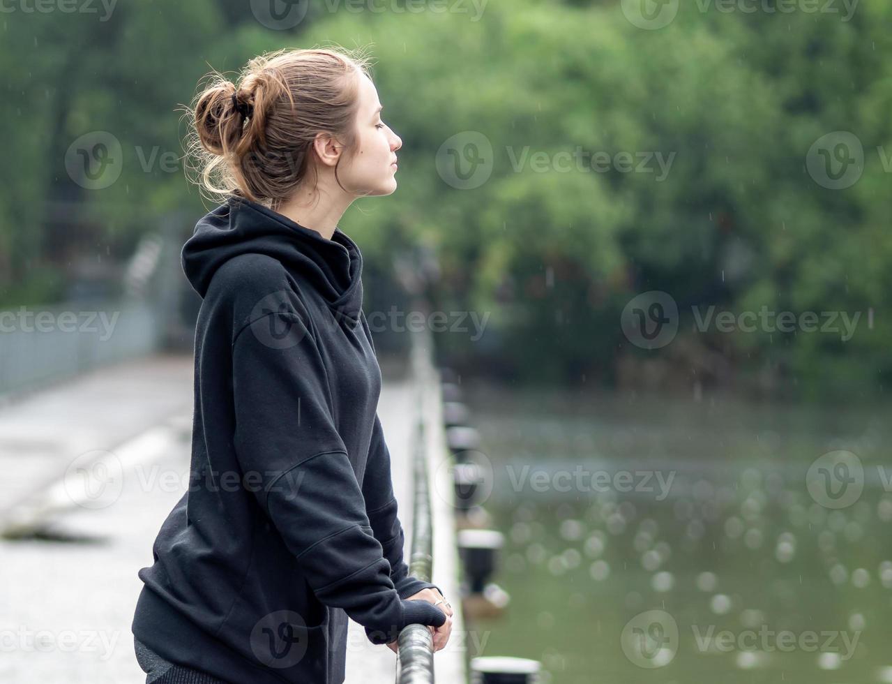 porträtt av ung flicka leende. skön kvinna stående ett person utomhus. en glad, lång brunetthårig, brun ögon kvinna har en positiv känsla frihet av fritid aktivitet i en naturlig parkera. foto