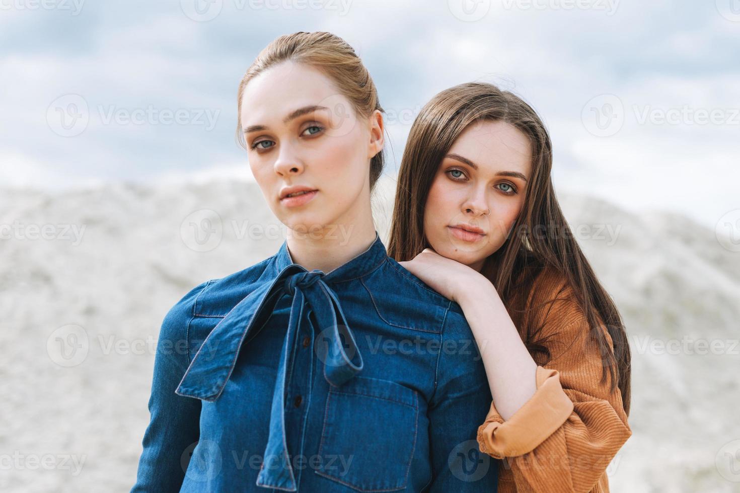 mode skönhet porträtt av ung kvinnor systrar i brun organisk sammet jeans shirts på öken- bakgrund foto