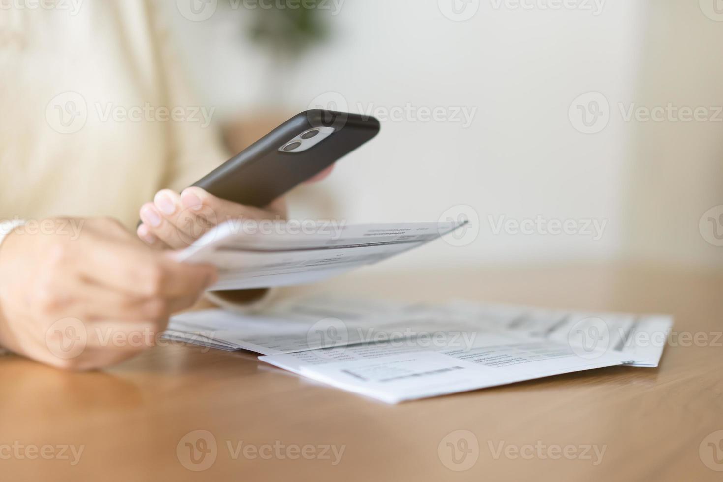 kvinna betalande räkningar använder sig av mobil telefon. kontantlös betalning begrepp. foto