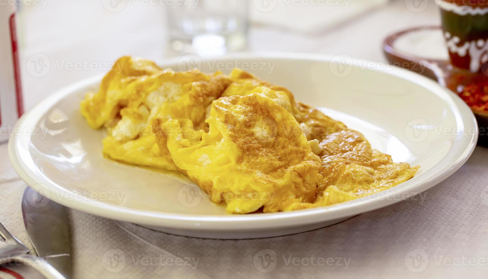 utsökt färsk omelett på en vit tallrik. selektiv fokus foto