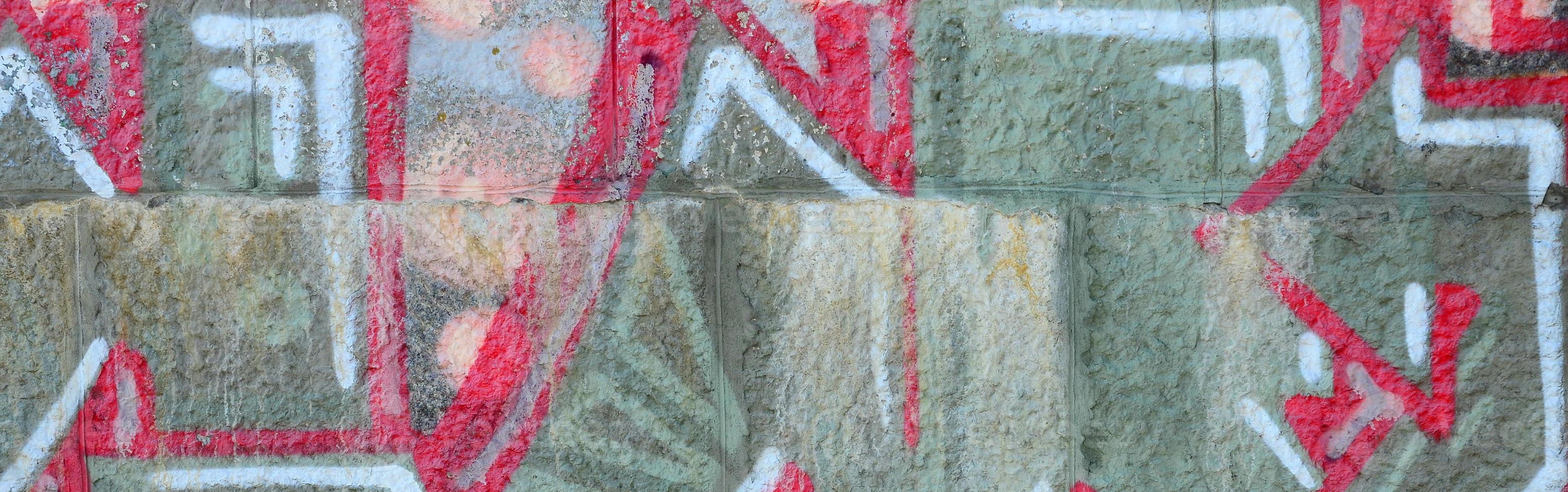 fragment av graffiti ritningar. de gammal vägg dekorerad med måla fläckar i de stil av gata konst kultur. färgad bakgrund textur i värma toner foto