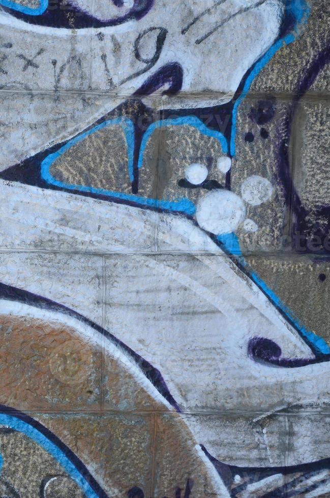 fragment av graffiti ritningar. de gammal vägg dekorerad med måla fläckar i de stil av gata konst kultur. färgad bakgrund textur i värma toner foto