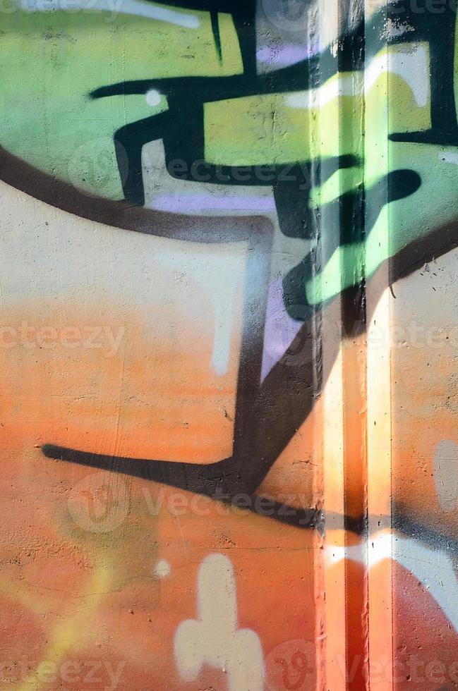 fragment av graffiti ritningar. de gammal vägg dekorerad med måla fläckar i de stil av gata konst kultur. färgad bakgrund textur i värma toner foto