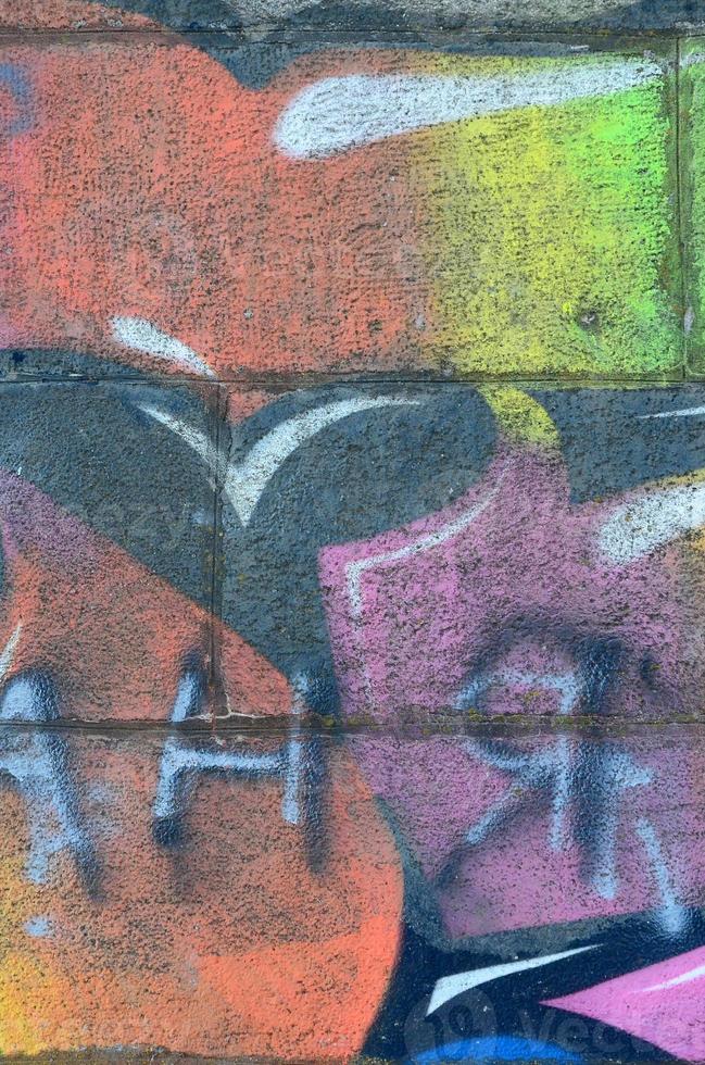 fragment av graffiti ritningar. de gammal vägg dekorerad med måla fläckar i de stil av gata konst kultur. flerfärgad bakgrund textur foto