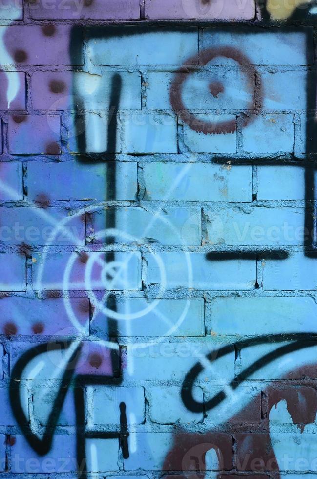 fragment av graffiti ritningar. de gammal vägg dekorerad med måla fläckar i de stil av gata konst kultur. färgad bakgrund textur i kall toner foto