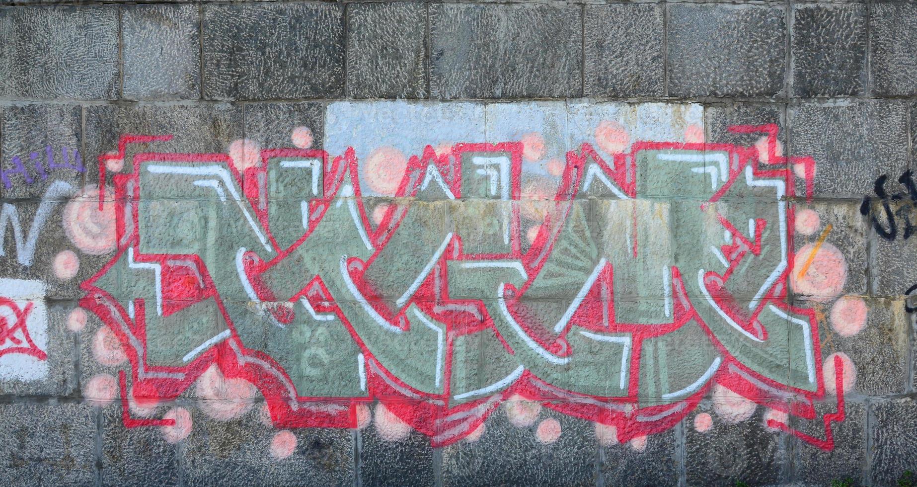 fragment av graffiti ritningar. de gammal vägg dekorerad med måla fläckar i de stil av gata konst kultur. färgad bakgrund textur i värma toner foto