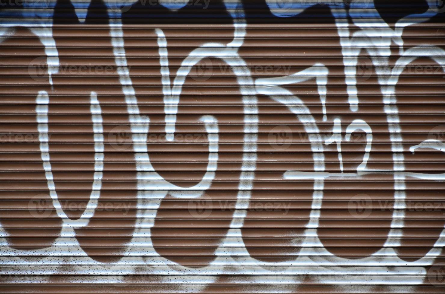 fragment av ett gammal färgad graffiti teckning på de slutare dörr. bakgrund bild som ett illustration av gata konst, vandalism och vägg målning med aerosol måla foto