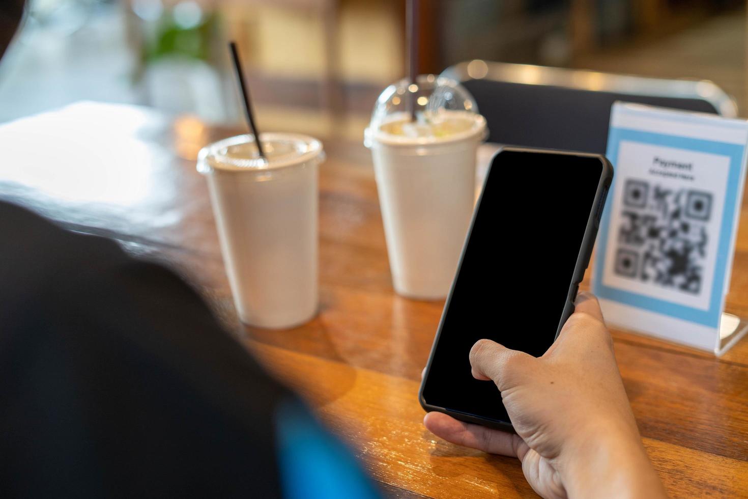 man använda sig av smartphone till skanna qr koda till betala i Kafé restaurang med en digital betalning utan kontanter. välja meny och beställa ackumulera rabatt. e plånbok, teknologi, betala uppkopplad, kreditera kort, Bank app foto