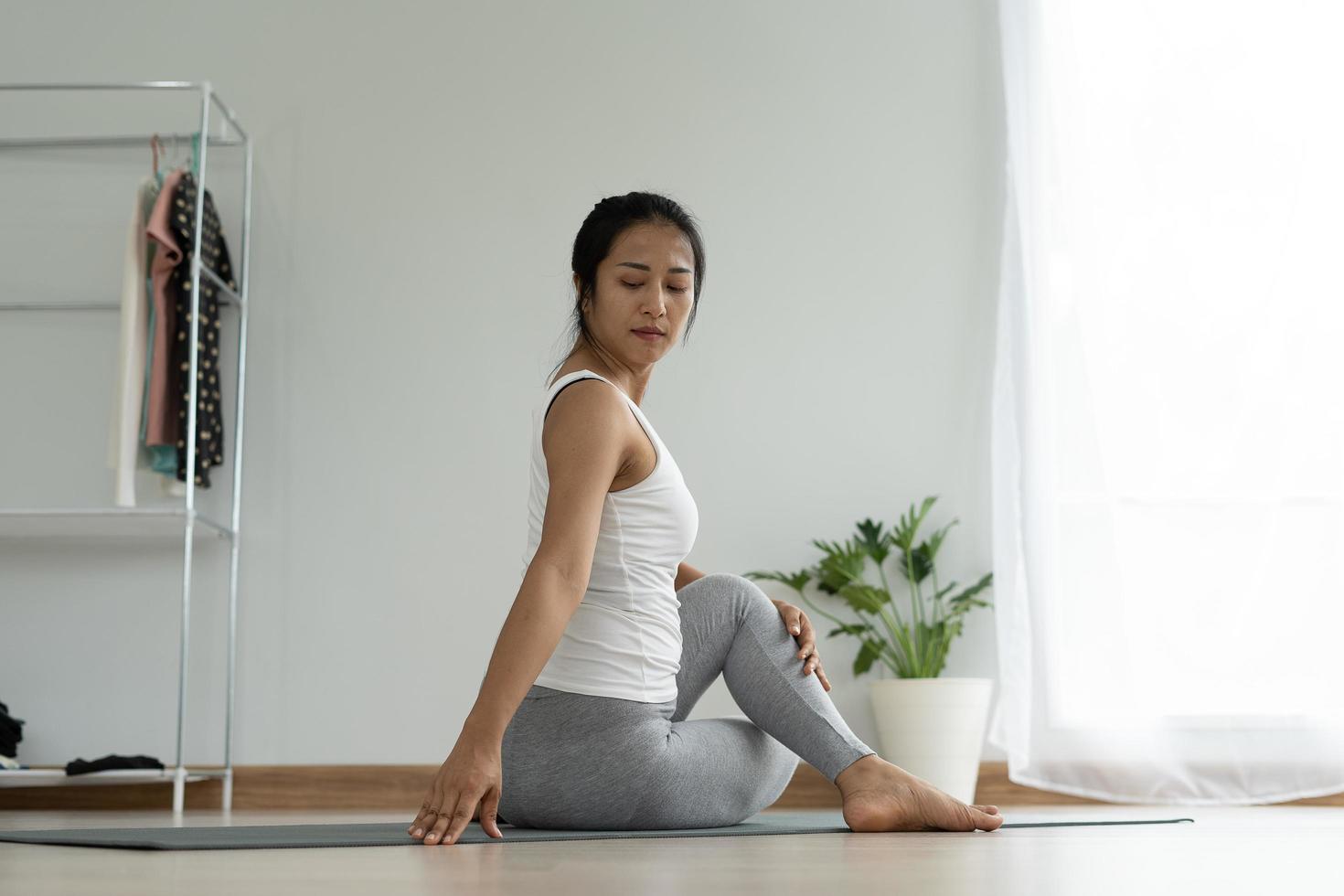 kvinna praktiserande meditera på de parkera. asiatisk kvinna håller på med övningar i morgon. balans, rekreation, avslappning, lugna, Bra hälsa, Lycklig, koppla av, friska livsstil, minska påfrestning, fredlig, attityd foto