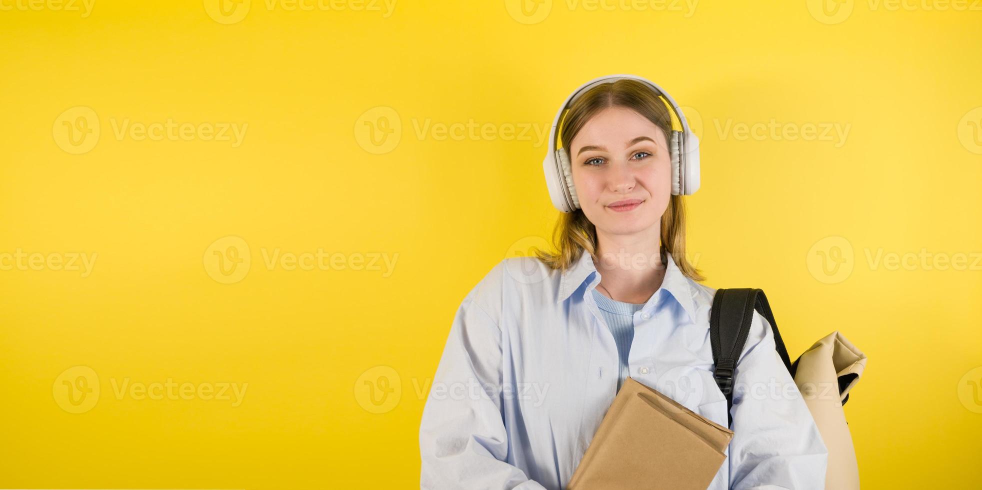 leende caucasian ung kvinna lyssnande till de podcast eller musik i de hörlurar och innehar böcker. utbildning konceptbanner med plats för skriva tillbaka till skola universitet foto