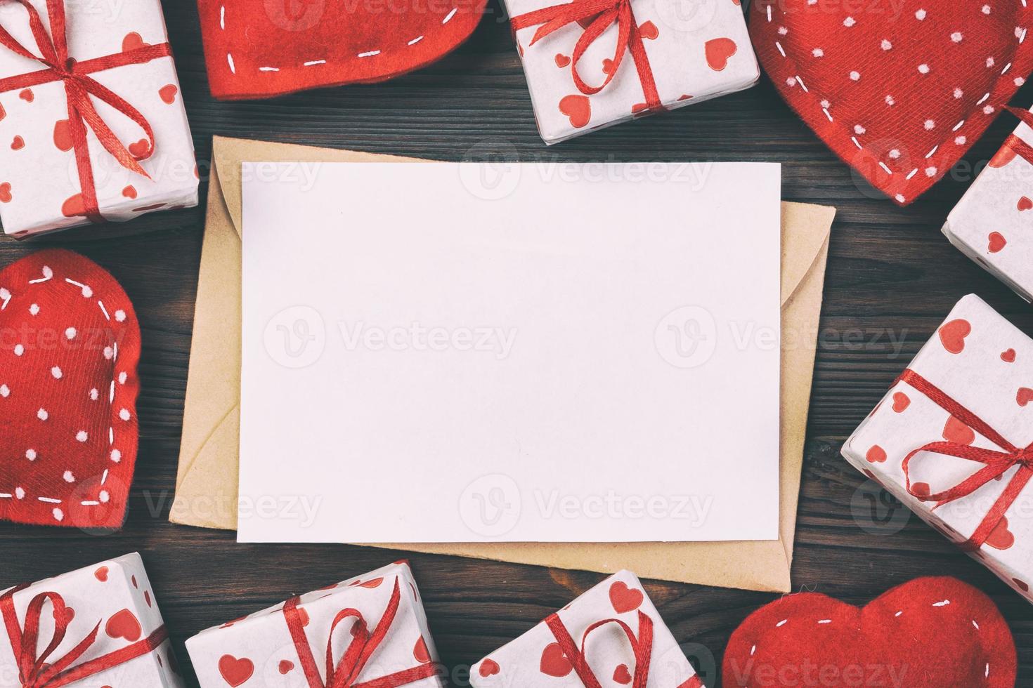 kuvert post med röd hjärta och gåva låda över mörk trä- bakgrund. valentine dag kort, kärlek eller bröllop hälsning begrepp foto