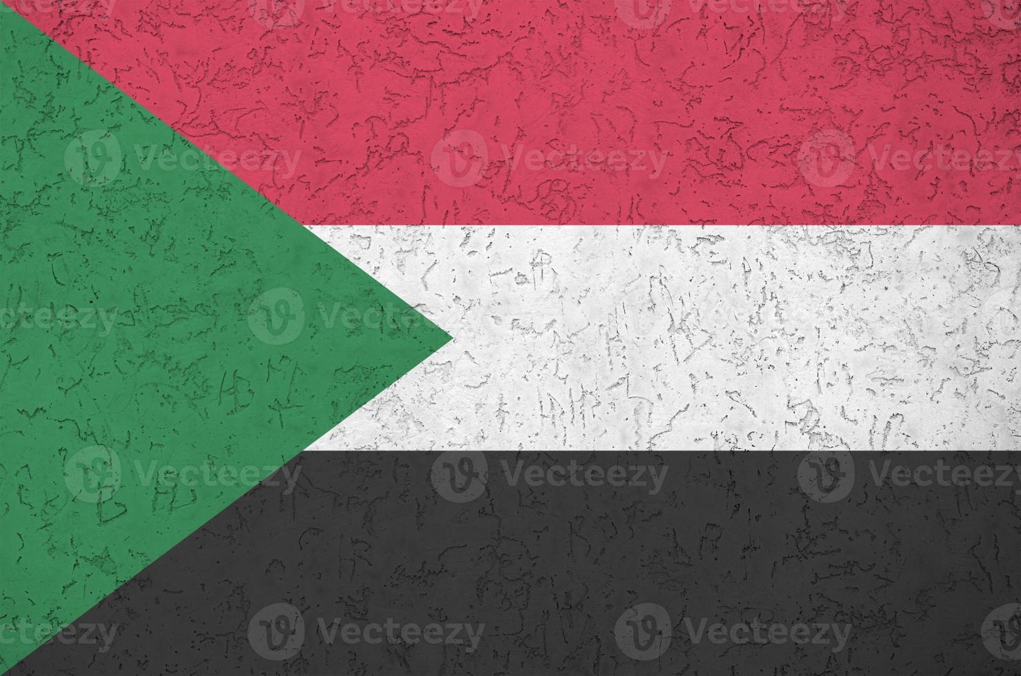 sudan flagga avbildad i ljus måla färger på gammal lättnad putsning vägg. texturerad baner på grov bakgrund foto