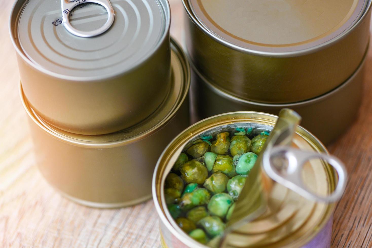 konserverad mat i metall kan på trä- bakgrund , topp se konserverad varor icke förgänglig mat lagring varor i kök Hem konserverad ärtor foto