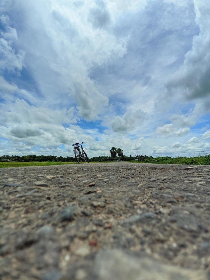 lång by väg i chandpur, bangladesh. ett tömma cykel stående på de väg sida. foto