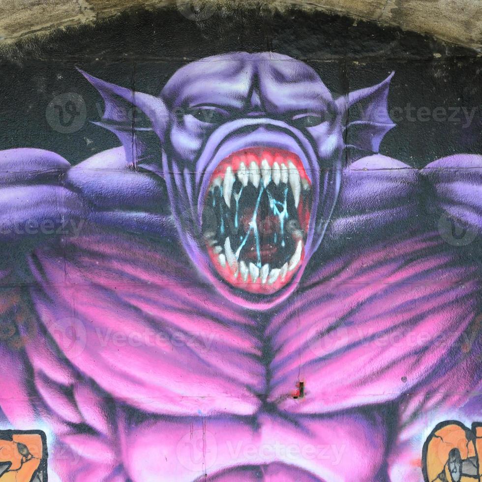 fragment av graffiti ritningar. de gammal vägg dekorerad med måla fläckar i de stil av gata konst kultur. lila skrämmande monster foto