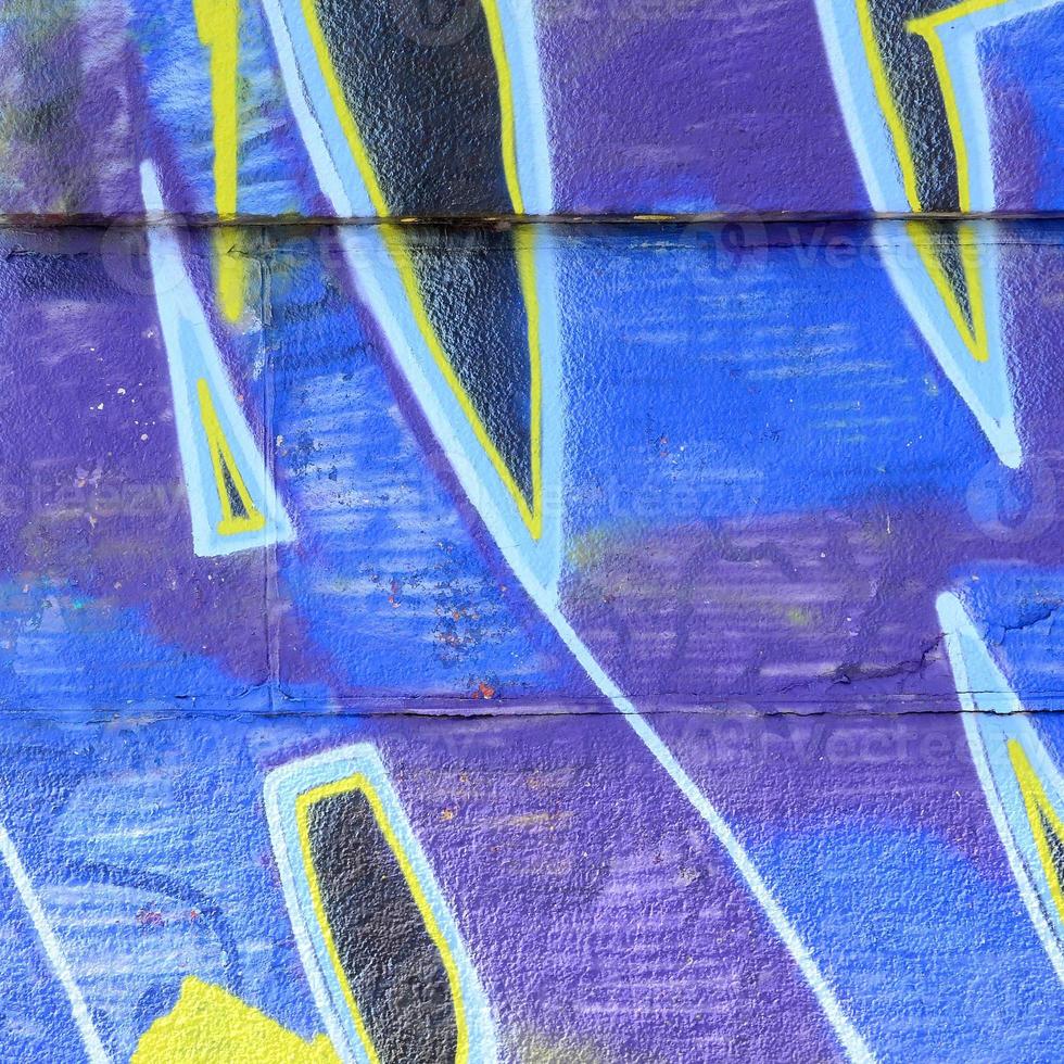 fragment av graffiti ritningar. de gammal vägg dekorerad med måla fläckar i de stil av gata konst kultur. färgad bakgrund textur i kall toner foto