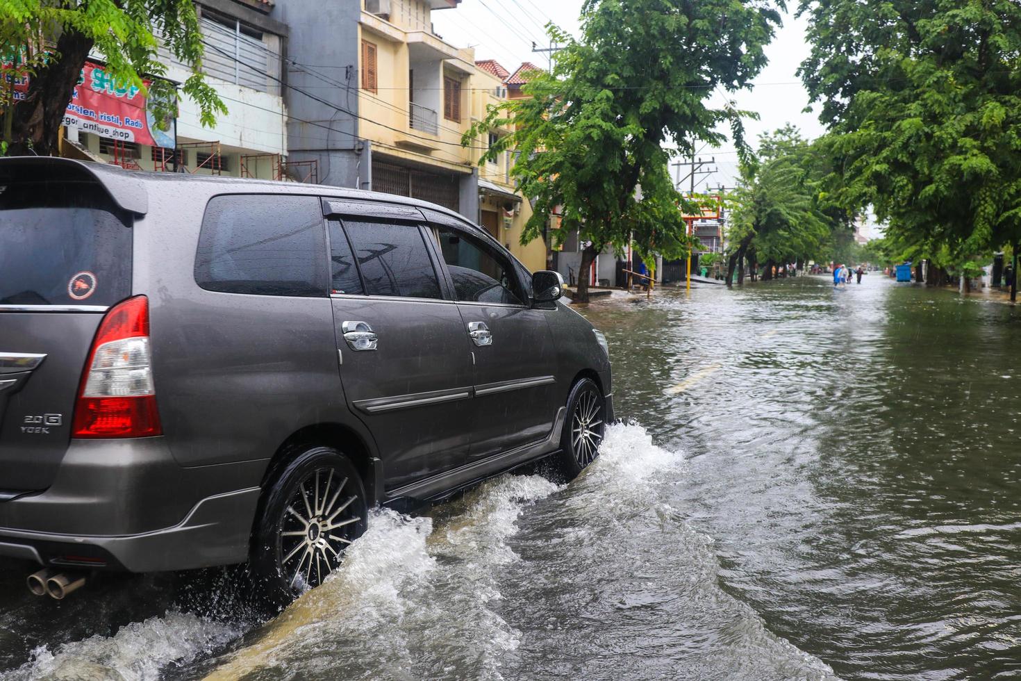 semarang, december 2022. några människor är gående genom de översvämning den där träffa de poncol tåg station område och några invånare är framställning till evakuera. fordon träffa de översvämning foto