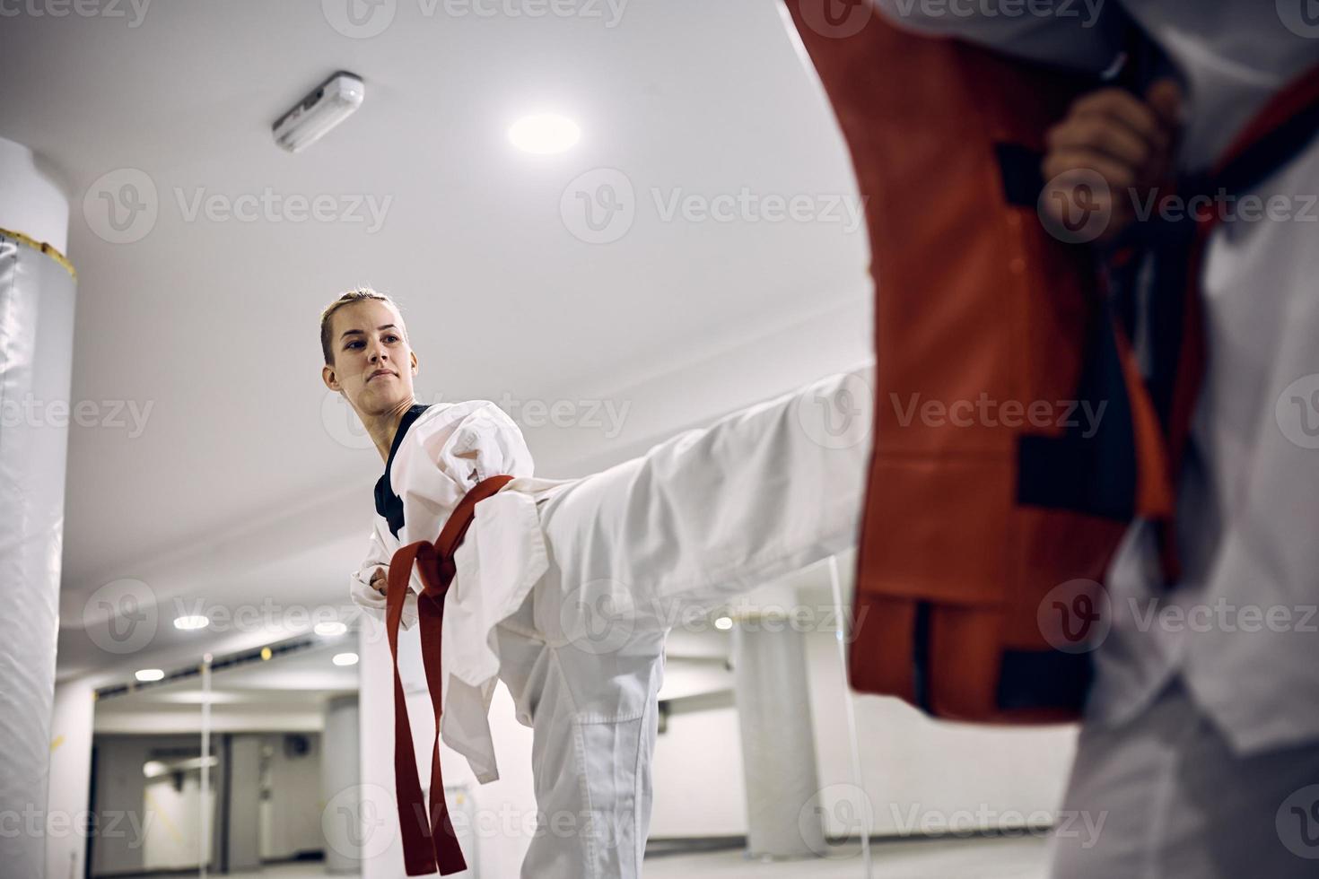 taekwondo kämpe med para-förmåga praktiserande henne ben sparka med tränare i hälsa klubb. foto