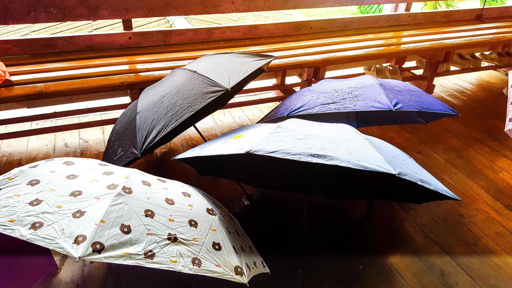 annorlunda Färg paraplyer på brun trä- golv foto