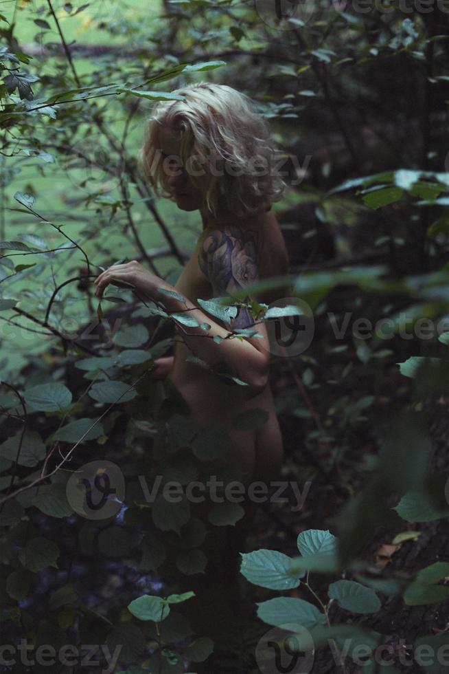 ung naken lady dölja i grön buskar naturskön fotografi foto