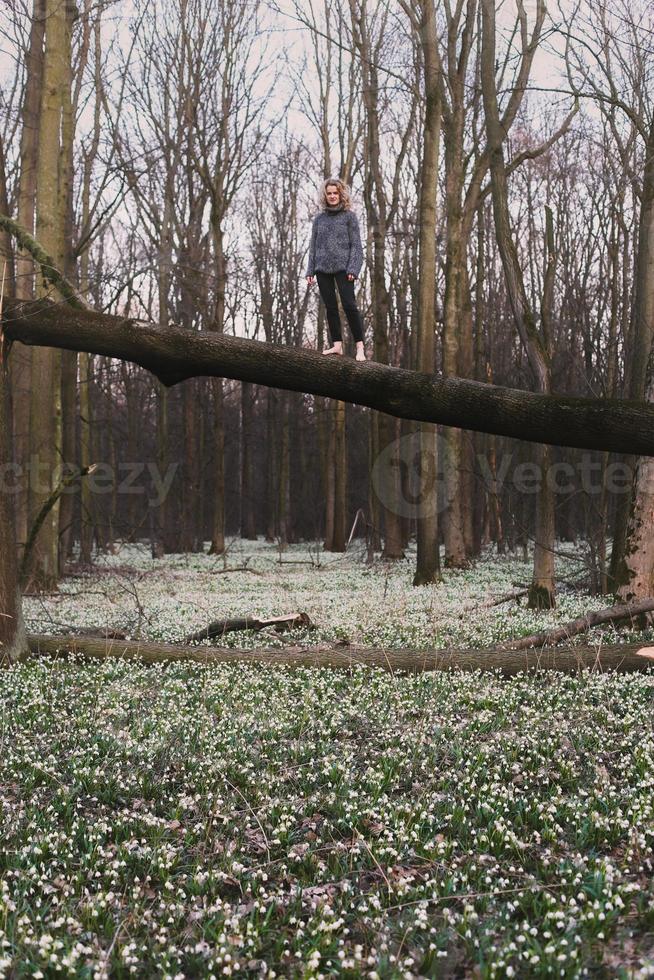 modig lady stående på träd trunk över glänta naturskön fotografi foto