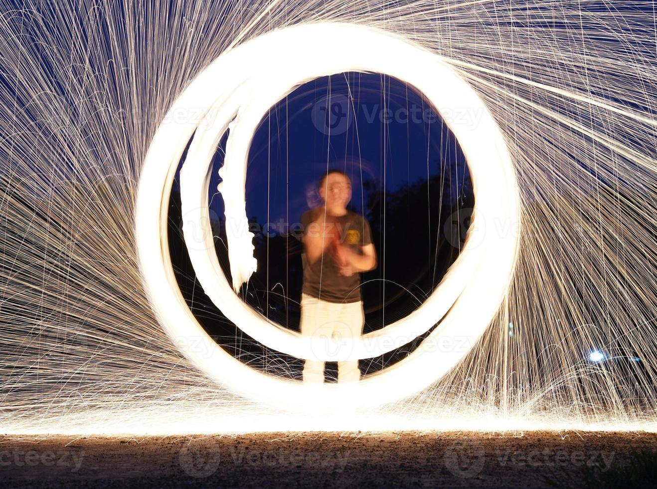 spinning och brinnande stål ull gnistra brand i de cirkel form med lång hastighet slutare skjuta lysande ljus linje till de jord. foto