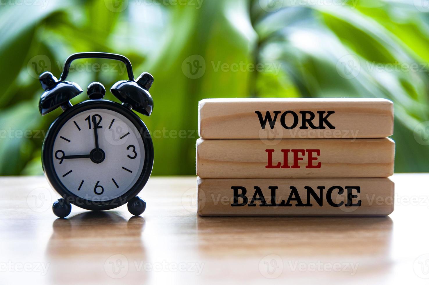 larm klocka pekande på 09:00 med arbete liv balans text på trä- block. arbete liv balans begrepp foto