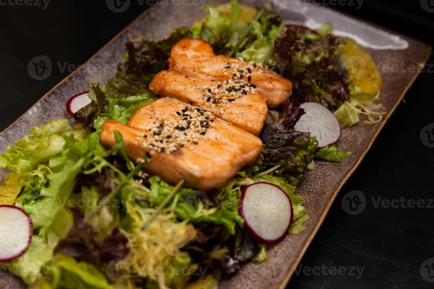 bakad lax filea med färsk grönsaker sallad. foto