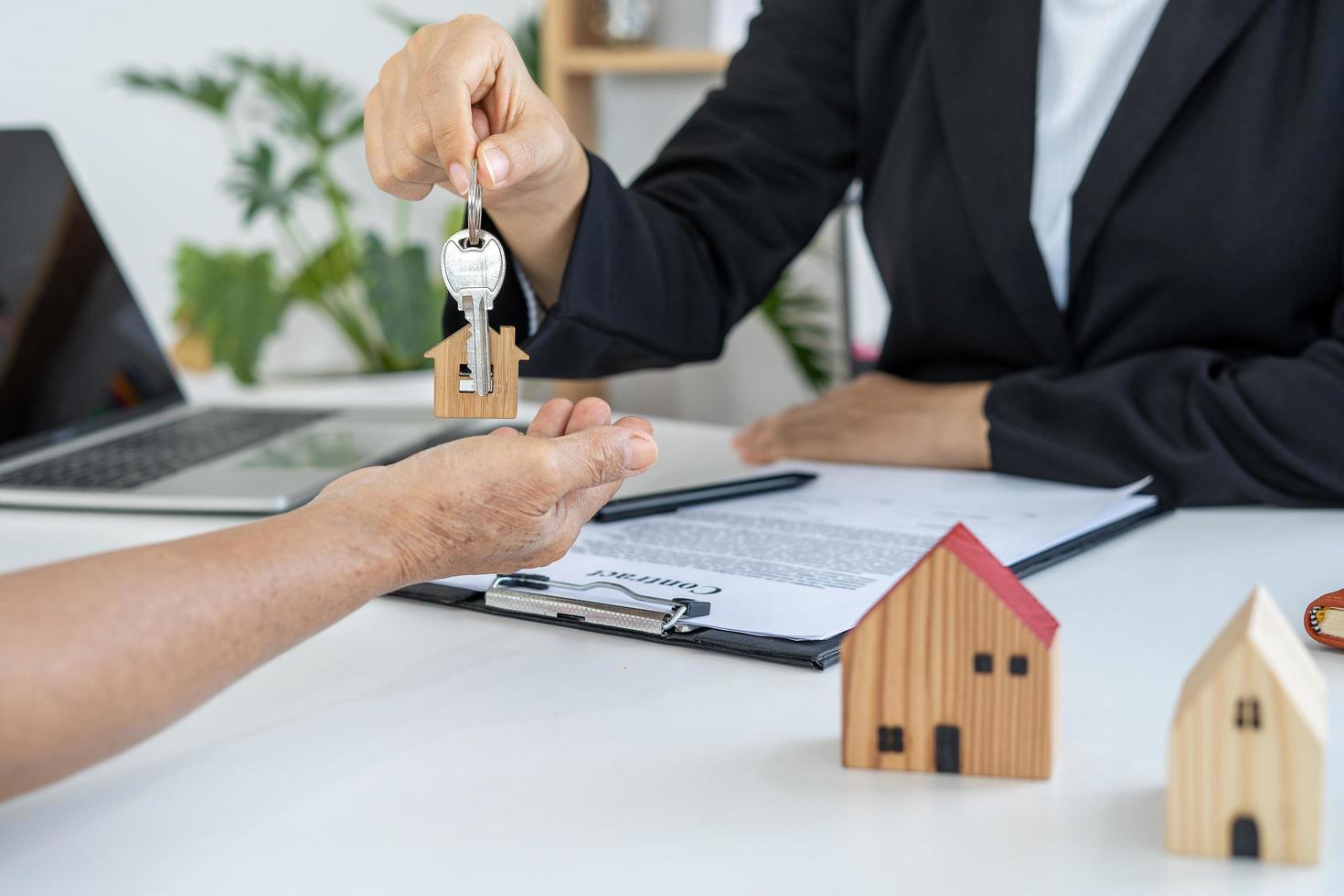 verklig egendom agenter ge nyckel till husägare efter avtal till köpa sälja. foto