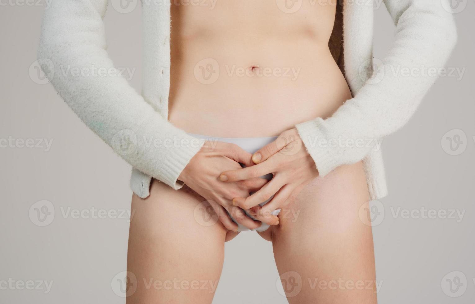 ung skön kvinna i smärtsam uttryck innehav henne mage lidande menstruations- period smärta liggande ledsen på Hem säng har mage kramp i kvinna hälsa begrepp foto