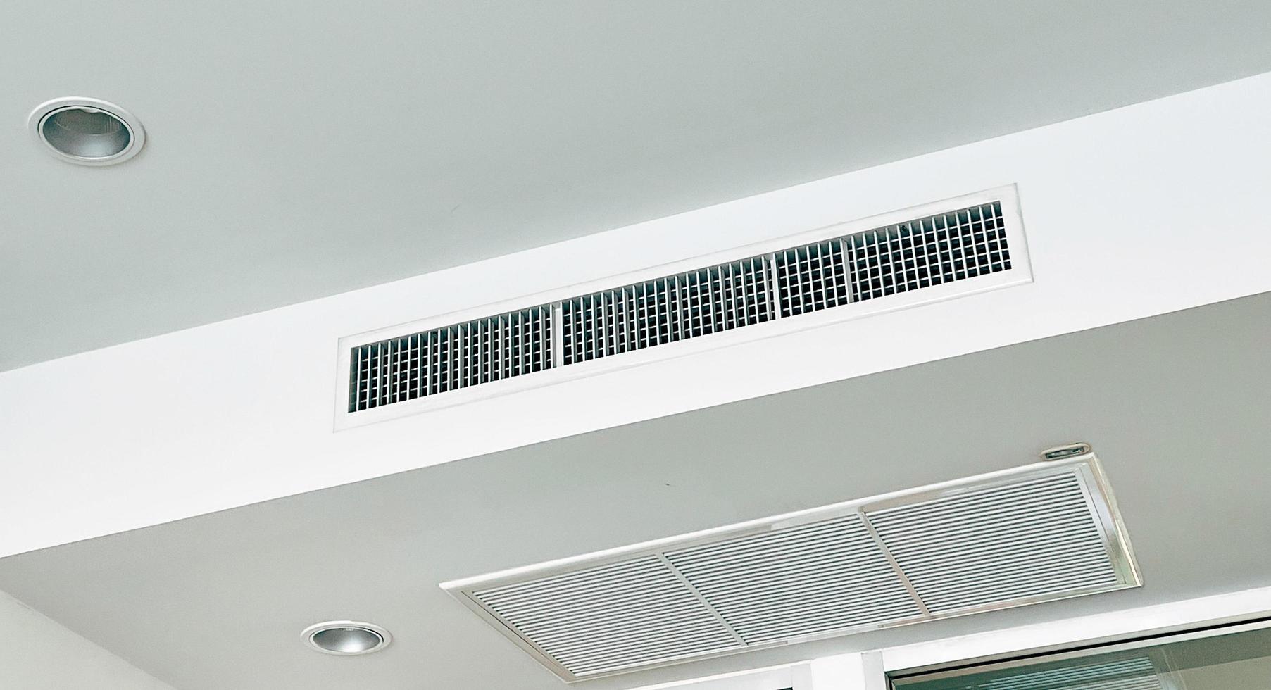tak monterad kassett typ luft balsam och modern lampa ljus på vit tak. kanal luft balsam för Hem, hall eller kontor. foto