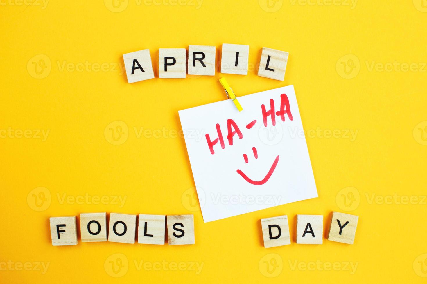 klistermärke med smiley och inskrift april dårar dag tillverkad förbi trä- kuber på gul bakgrund. foto
