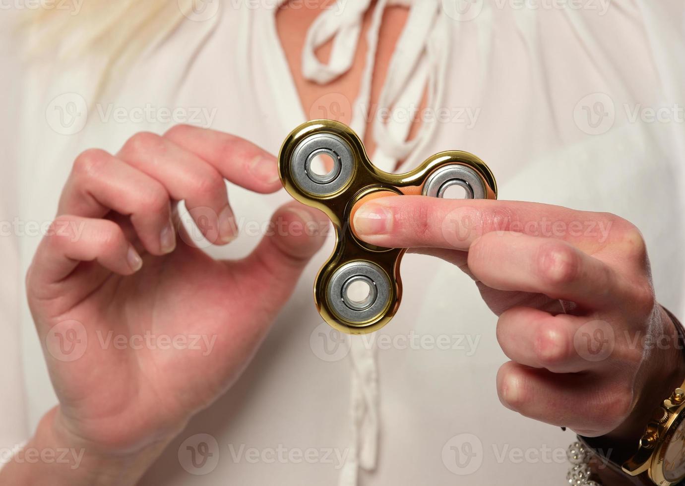 flicka till spela med fidget spinnare i hans händer, de begrepp av lindra påfrestning, utveckla en små hand matematik. foto