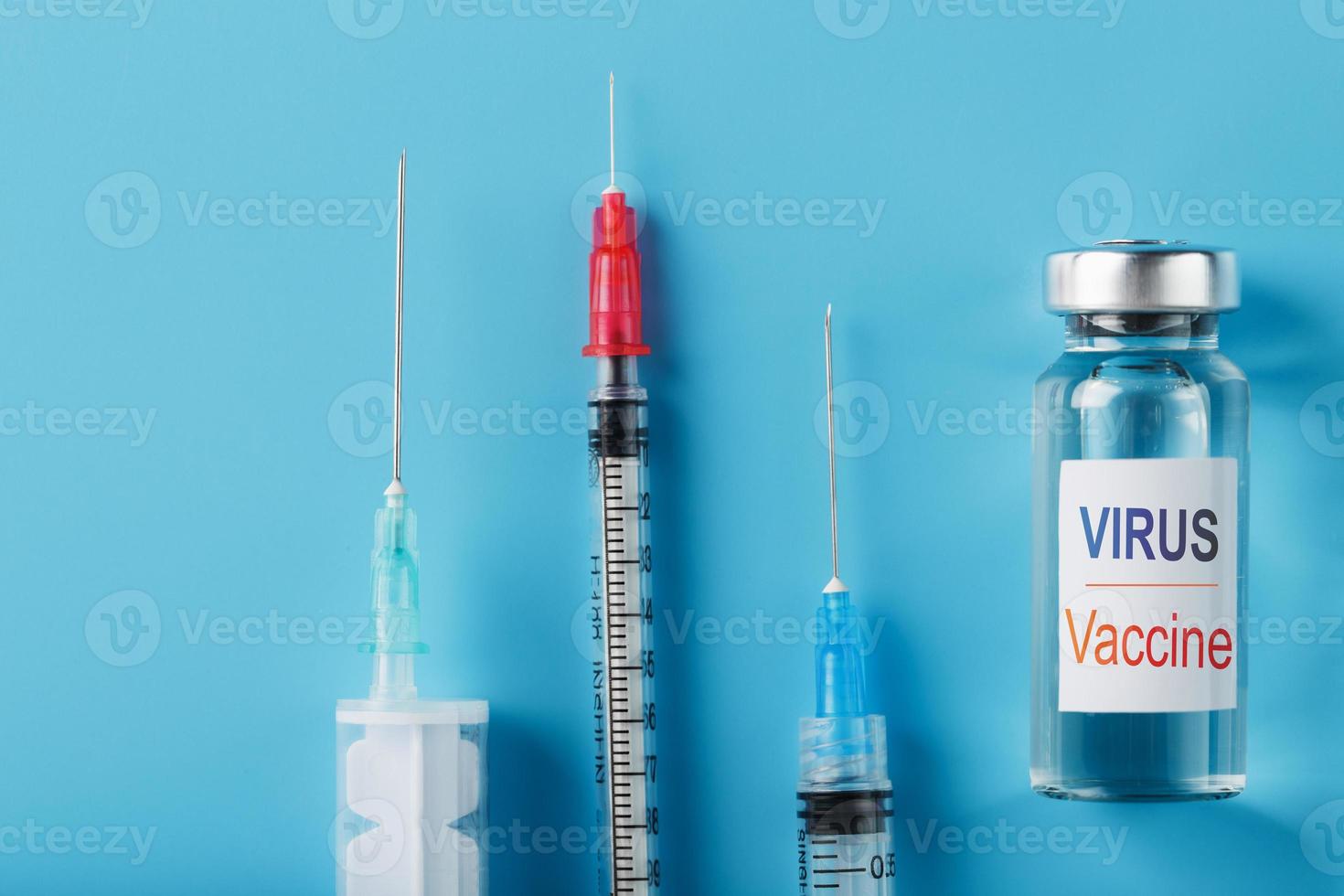 sprutor och ampull med de vaccin mot de virus från sjukdomar på en blå bakgrund. foto