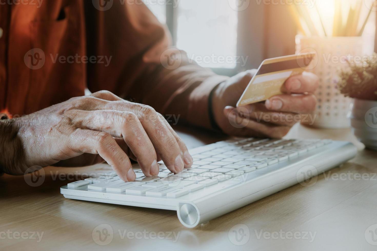 man hand innehav kreditera kort och använder sig av bärbar dator. uppkopplad handla. foto