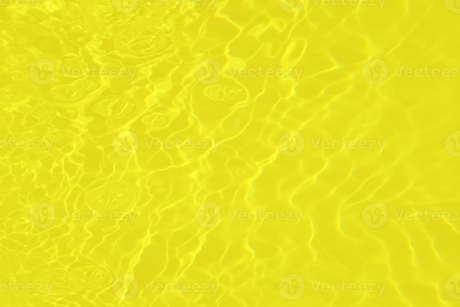 defokusering suddig transparent gul färgad klar lugna vatten yta textur med stänk och bubblor. trendig abstrakt natur bakgrund. vatten vågor i solljus med kaustik. guld vattenfärg glans foto