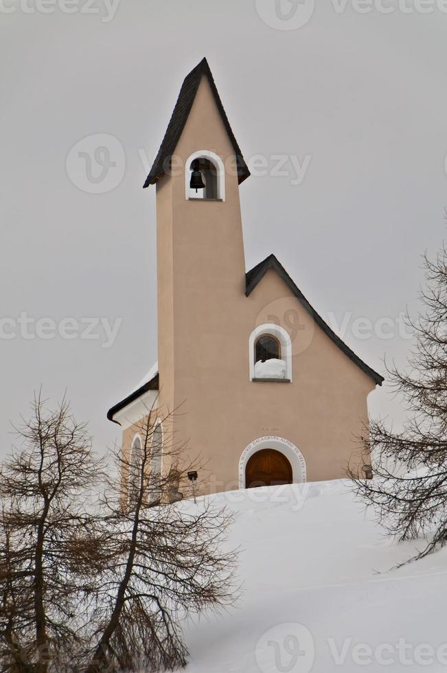 en små berg kyrka i snö bakgrund vinter- tid foto