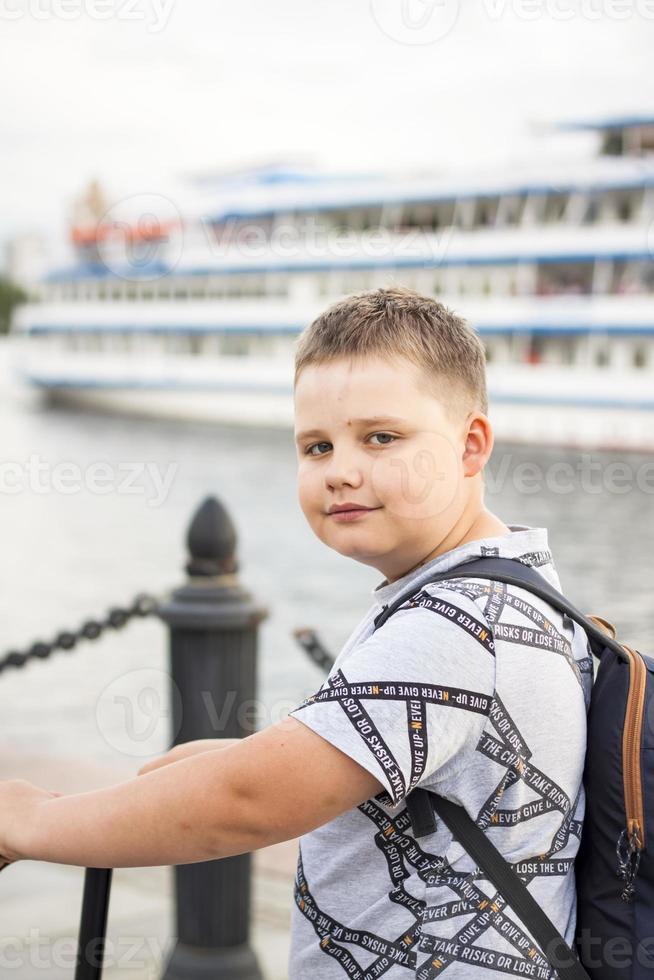 porträtt av en pojke på de bakgrund av en flod fartyg. flod station. foto