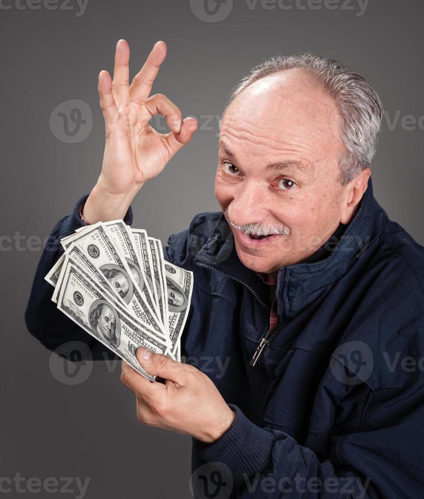 äldre man som visar fläkt av pengar foto