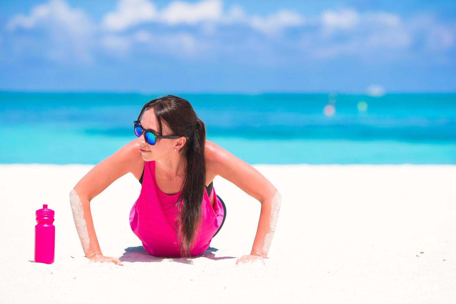 kvinna gör armhävningar på en strand foto