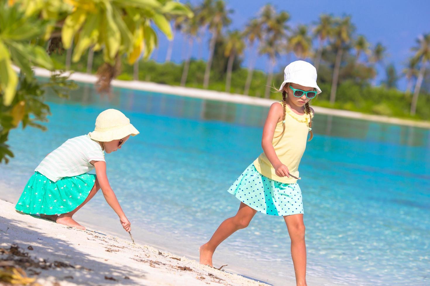 två tjejer som har kul på en tropisk strand foto