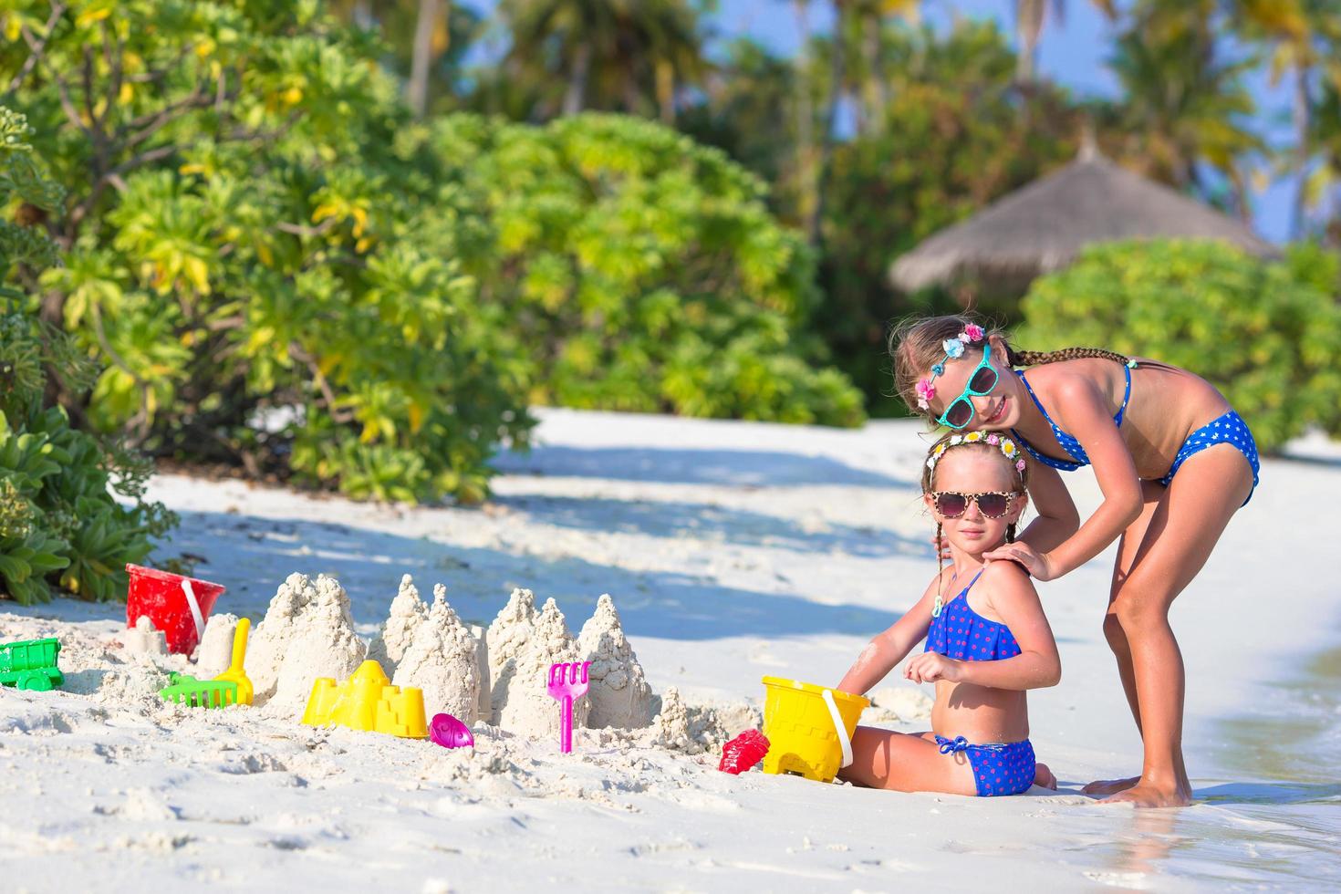 två flickor som leker i sanden på en strand foto